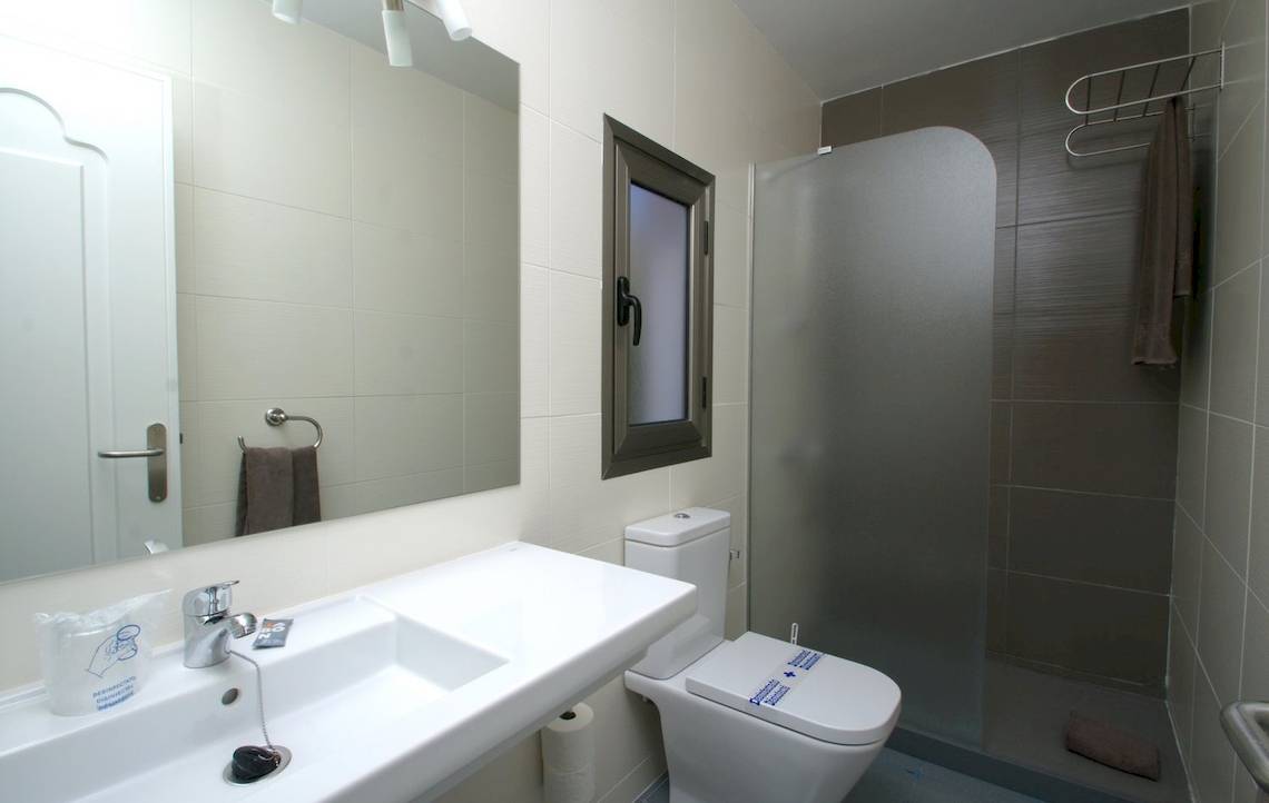 Badezimmer im Turbo Club mit Spiegel, Waschbecken, Toilette und Duschkabine.