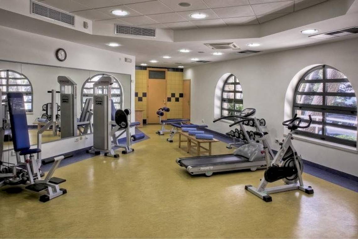 Fitnessraum im BlueSun Hotel Berulia mit verschiedenen Geräten und Geräten.