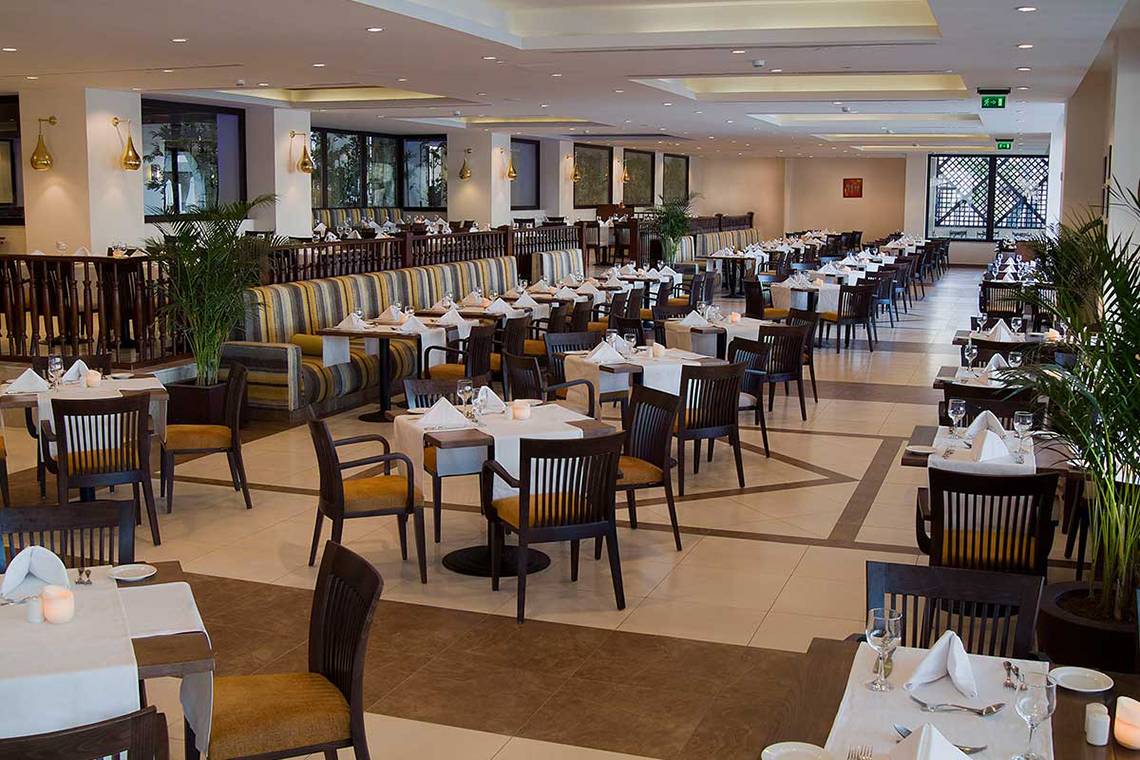 Restaurant im Steigenberger Aqua Magic mit gedeckten Tischen und Stühlen.