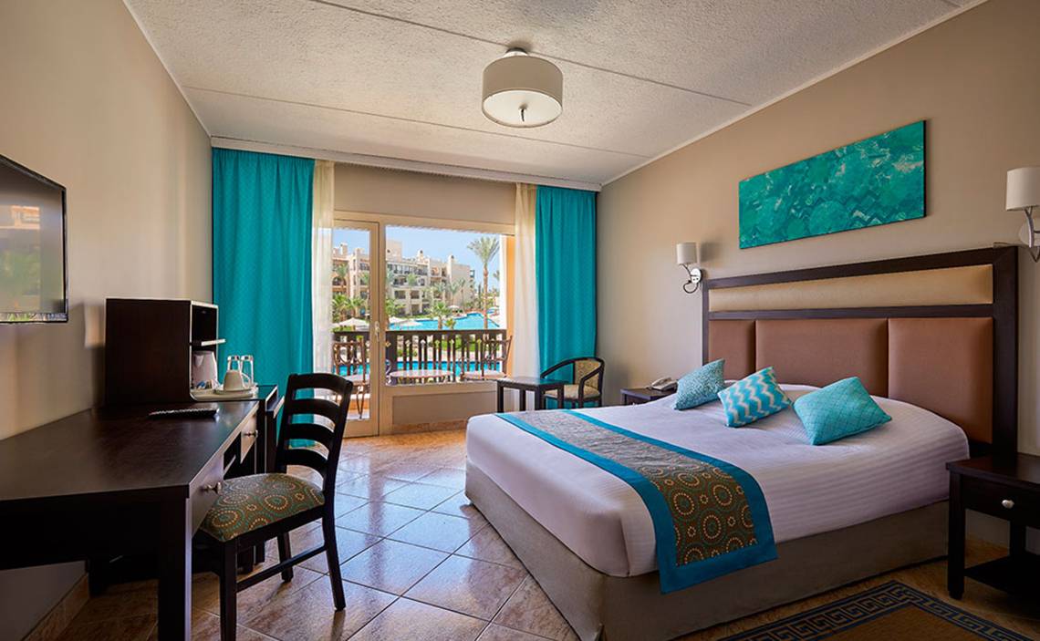 Hotelzimmer im Steigenberger Aqua Magic mit Bett, Schreibtisch, Stühlen, Fernseher und Balkon.