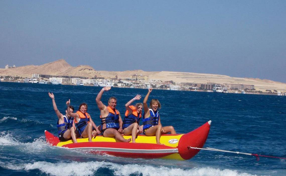 Gruppe auf rotem und gelbem Schlauchboot mit Stegenberger Aqua Magic im Hintergrund.