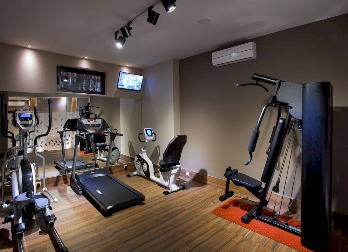 Fitnessstudio im Atlantis Beach Hotel auf Kreta mit diversen Geräten und Monitoren