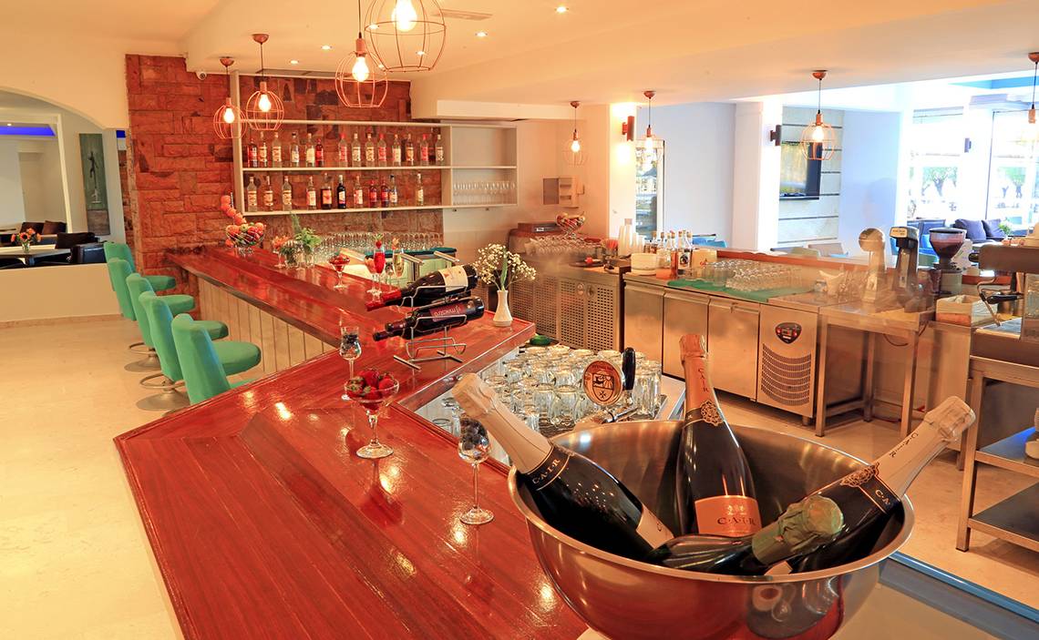 Innenansicht der Bar im Blue Bay Beach Resort mit Champagnerflaschen und Gläsern.