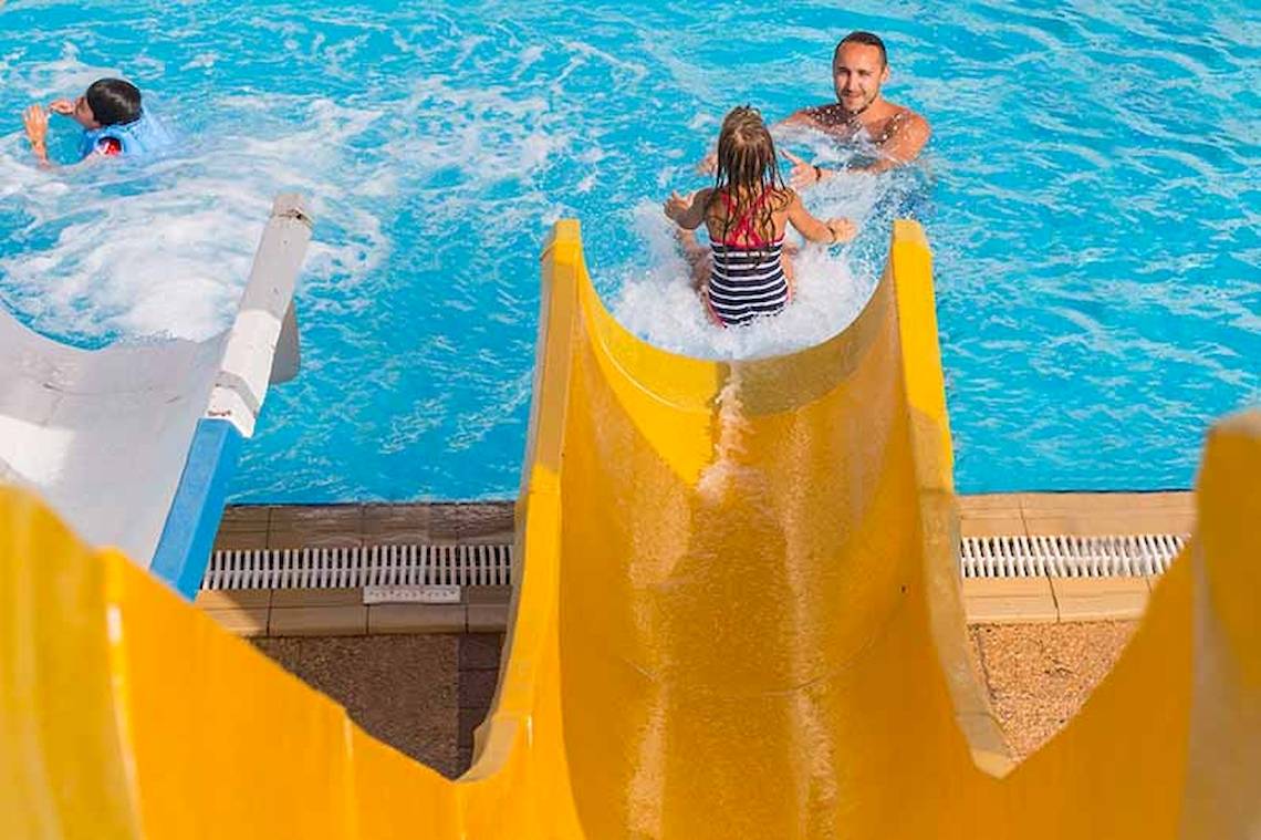 Familie im El Mouradi Skanes Hotel rutscht und schwimmt im Pool