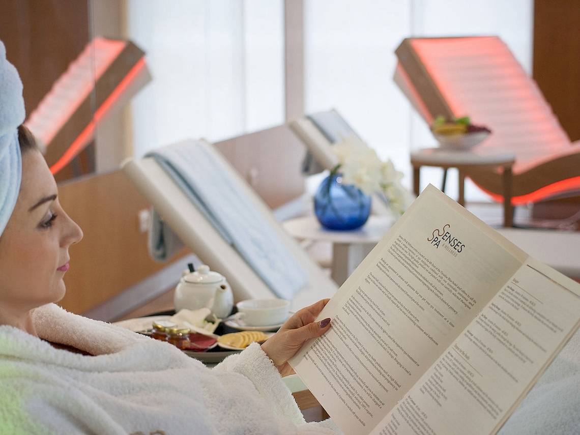 Frau im Bademantel liest das Behandlungsmenü im Spa des Maritim Hotel Paradise Blue Albena