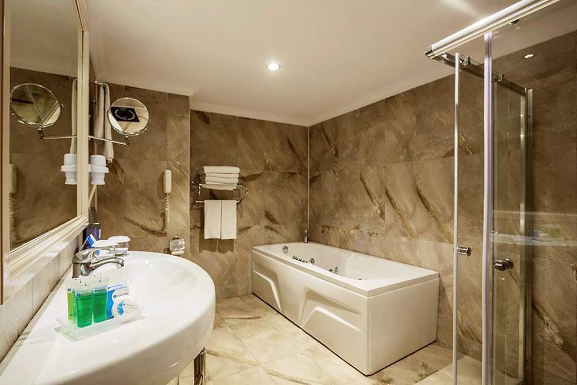 Ein elegantes Badezimmer im Turan Prince Hotel mit Badewanne und Dusche.