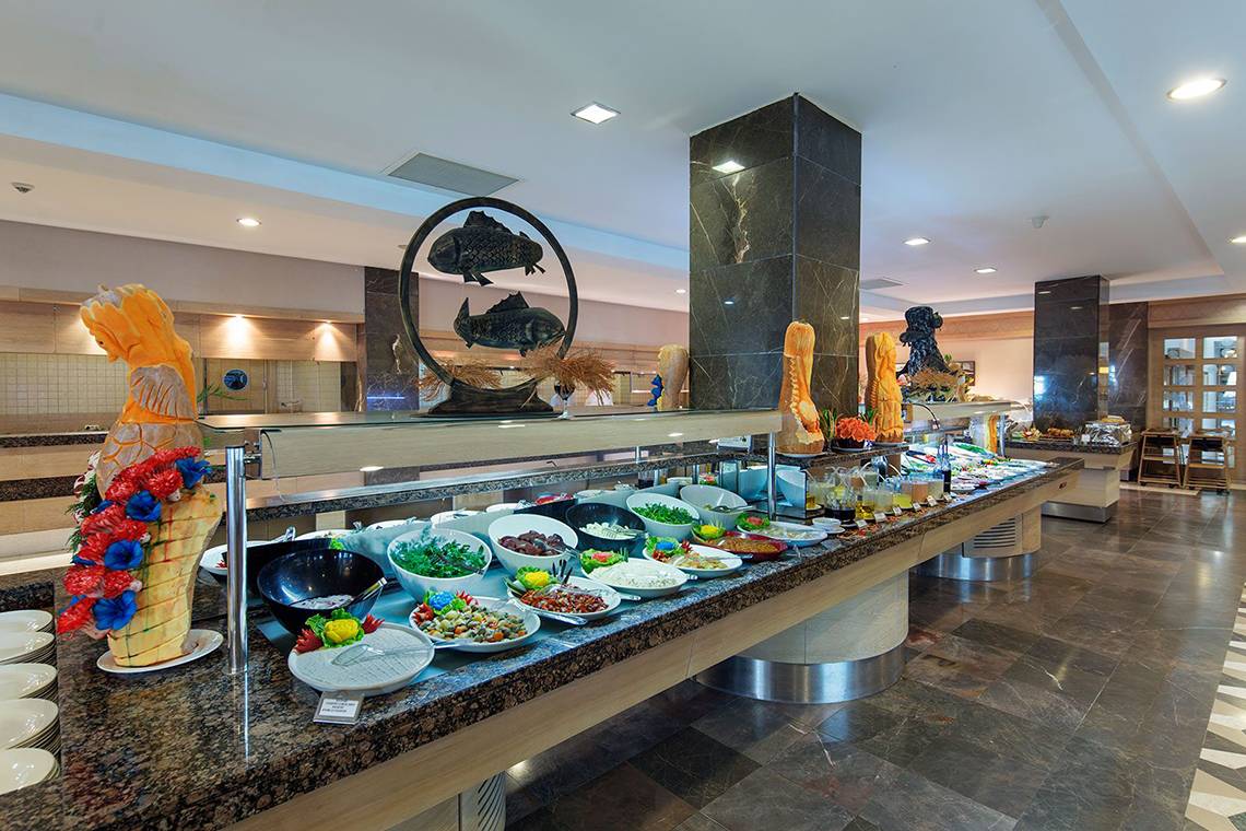 Buffet-Tisch im Alba Queen Hotel mit verschiedenen Gerichten und Dekorationen.