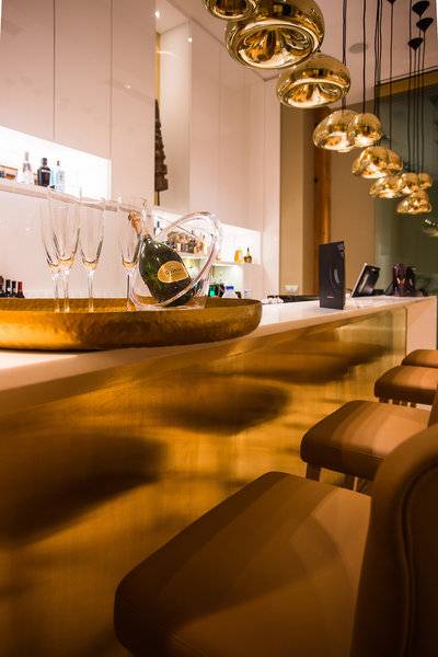 Empfangsbereich des Portugal Boutique Hotels mit Champagnerflasche, Gläsern und goldenen Pendelleuchten.
