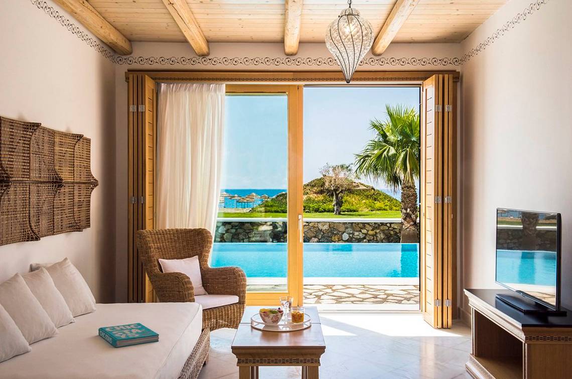 Wohnzimmer des Mitsis Blue Domes Resorts & Spa mit Blick auf den Pool und die Insel.