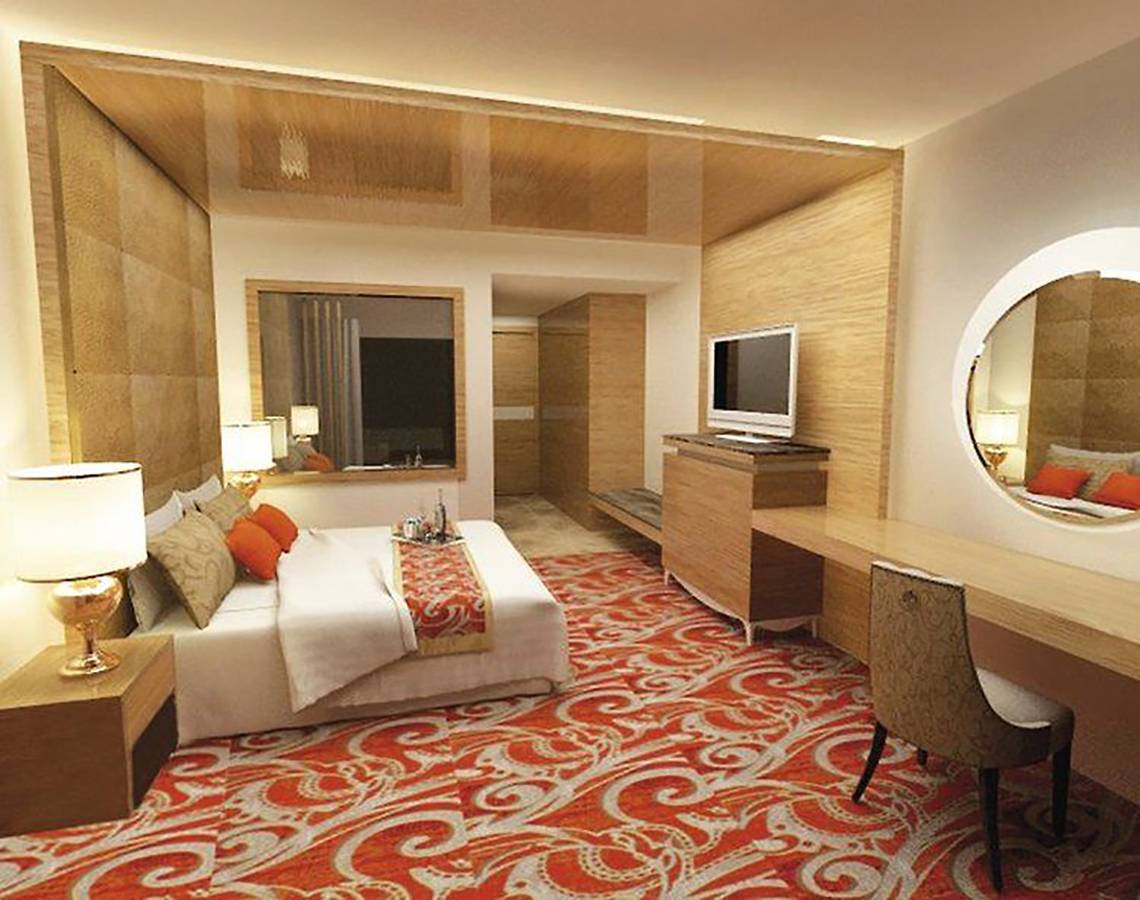 Hotelzimmer von Defne Defnem mit großem Bett, zwei Nachttischen, Schreibtisch, Stuhl, Spiegel und Fernseher.