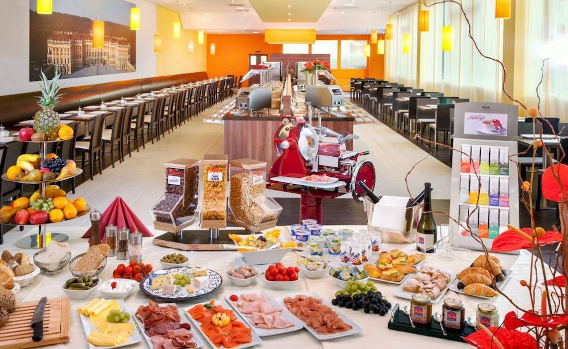Frühstücksbuffet im Star Inn Hotel Wien Schönbrunn mit einer Auswahl an Obst, Käse, Wurst, Brot und anderen Gerichten.
