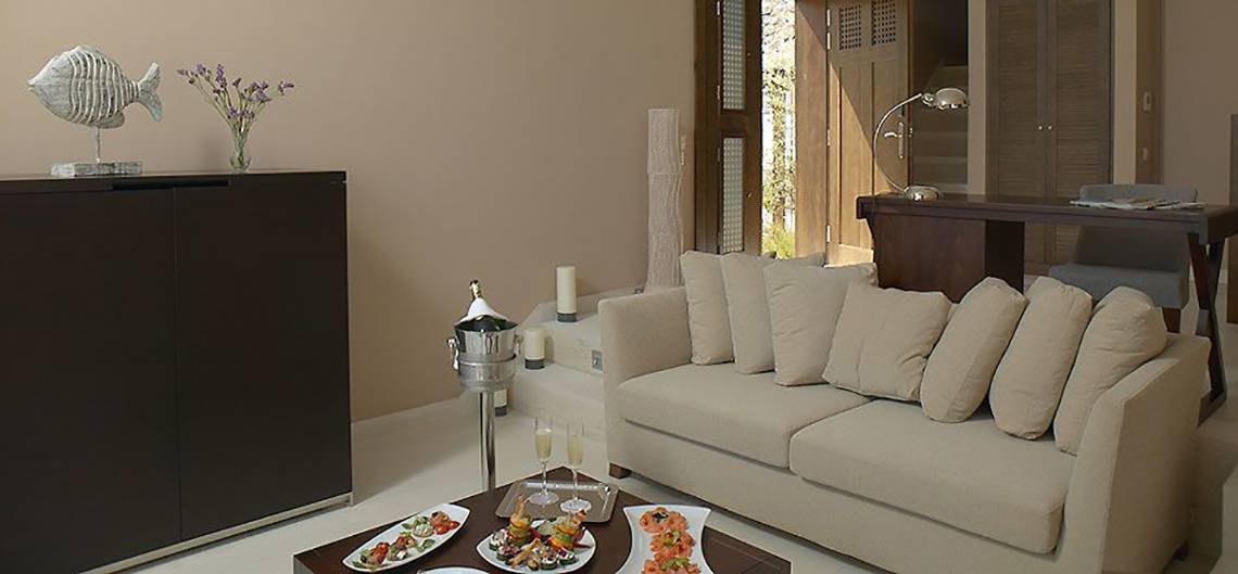 Wohnzimmer im Atlantica Belvedere Resort mit Sofa, Tisch und Essen