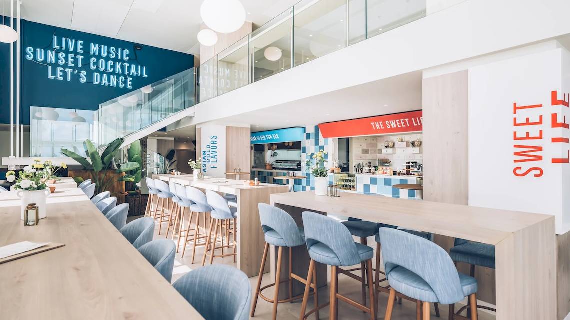 Innenansicht der Hotellobby des Iberostar Selection Sabila mit blauen Stühlen und Tischen.