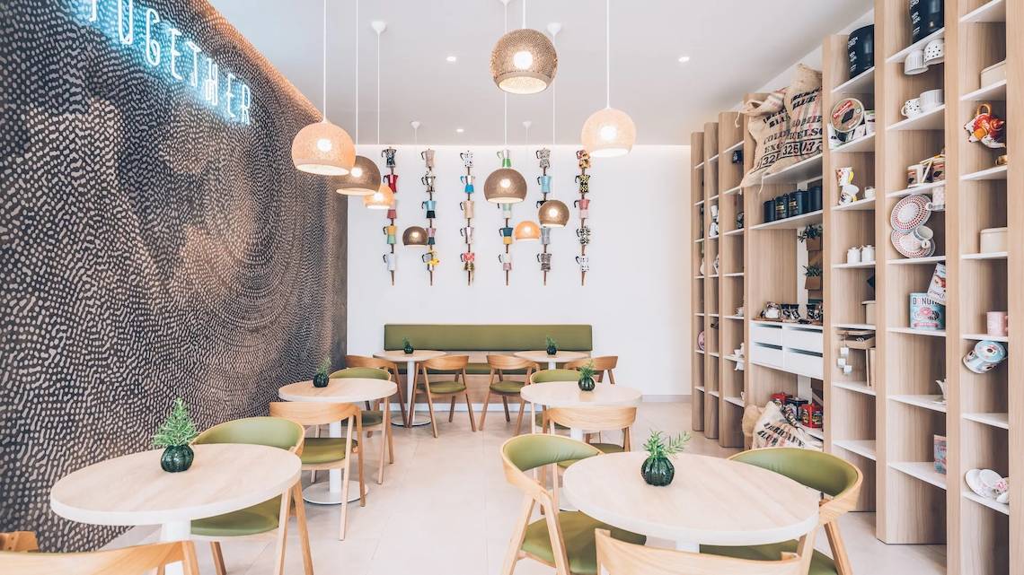 Inneneinrichtung des Iberostar Selection Sabila Hotels mit grünen Sofas, Holztischen und Regalen.