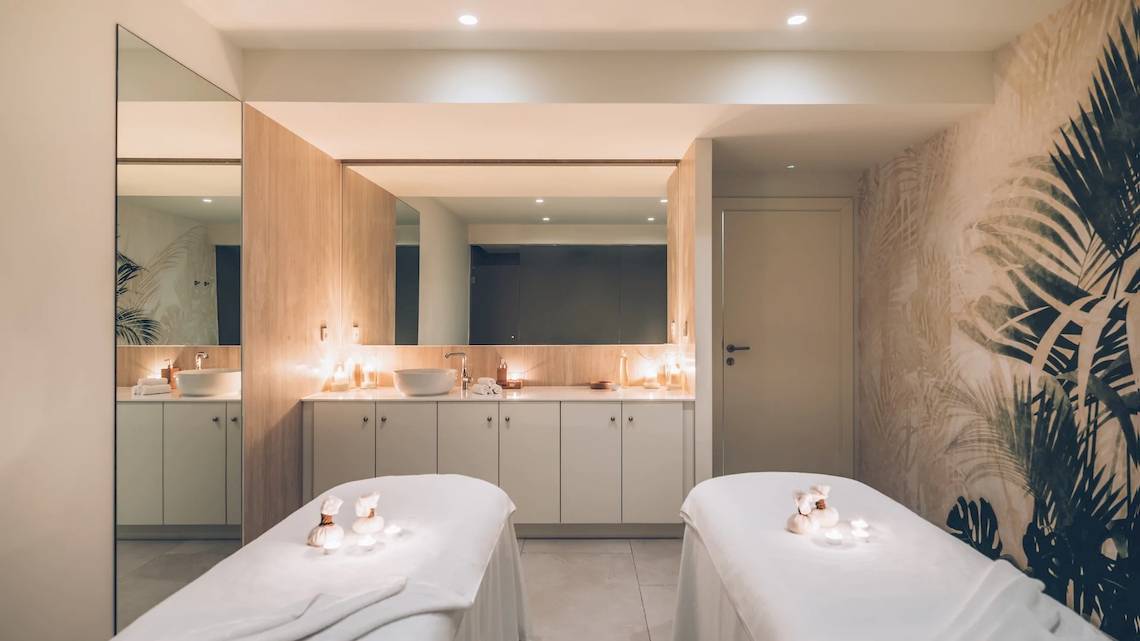 Massageraum im Iberostar Selection Sabila Hotel mit zwei Massagetischen, einem Spiegel und exotischen Wandmustern.