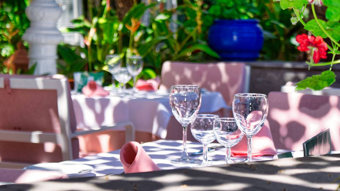 Ein Tisch im Restaurant von Parque Tropical, gedeckt mit Gläsern und Servietten, draußen im Garten.