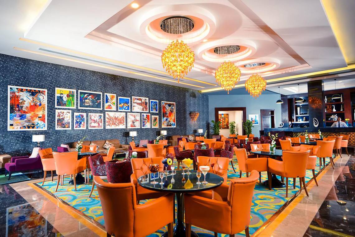 Lobby des Pickalbatros Royal Moderna Resorts mit orangen Stühlen und Tischen.