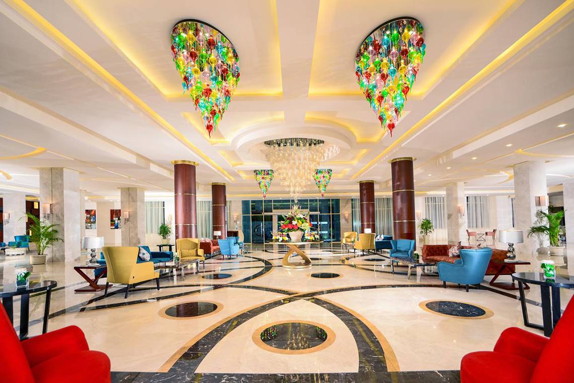 Lobby des Pickalbatros Royal Moderna Resorts mit farbenfrohen Kronleuchtern und farbenfrohen Stühlen.