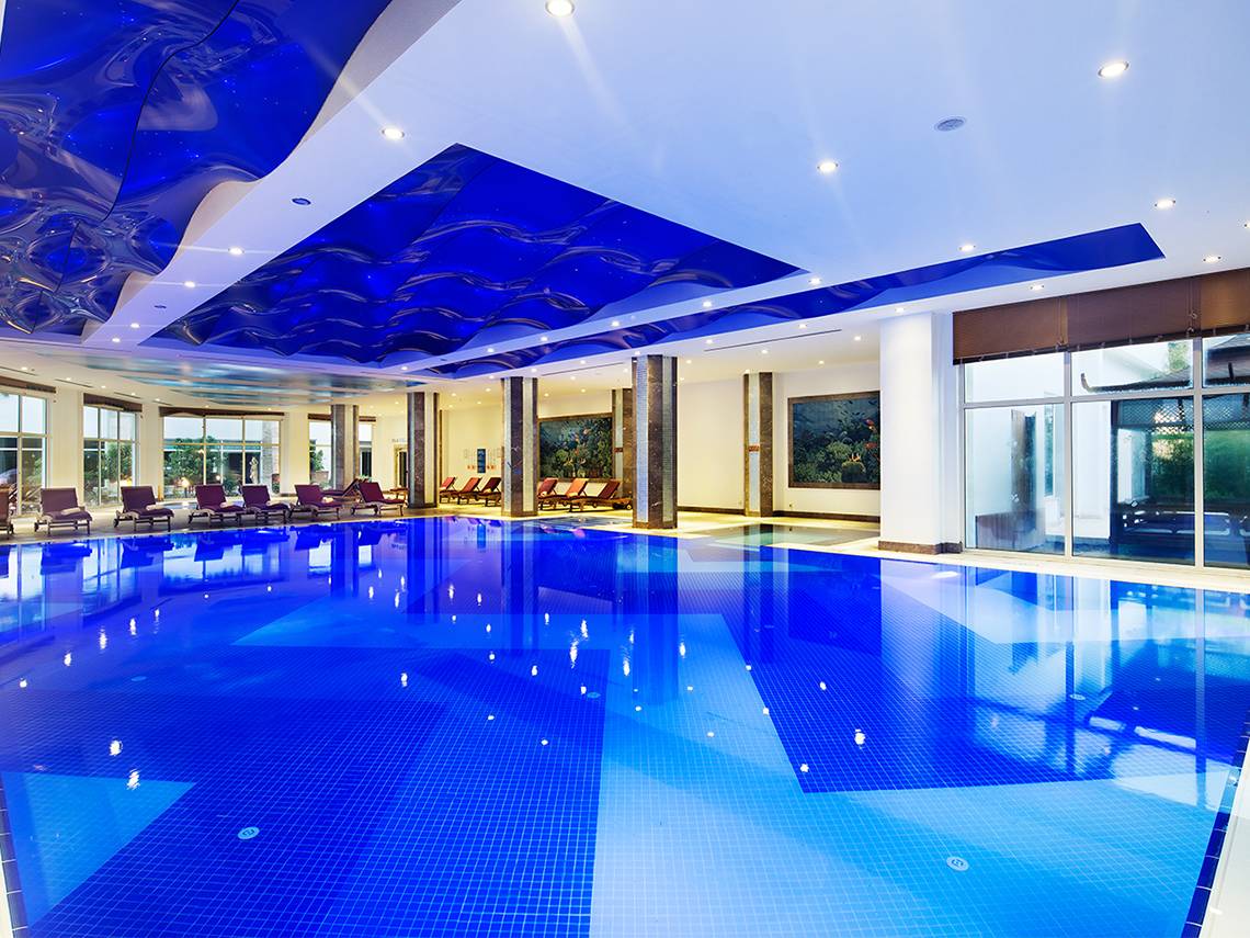 Innenpool des Crystal Waterworld Aqua Collection Hotels mit blauer Decke und blauem Wasser.