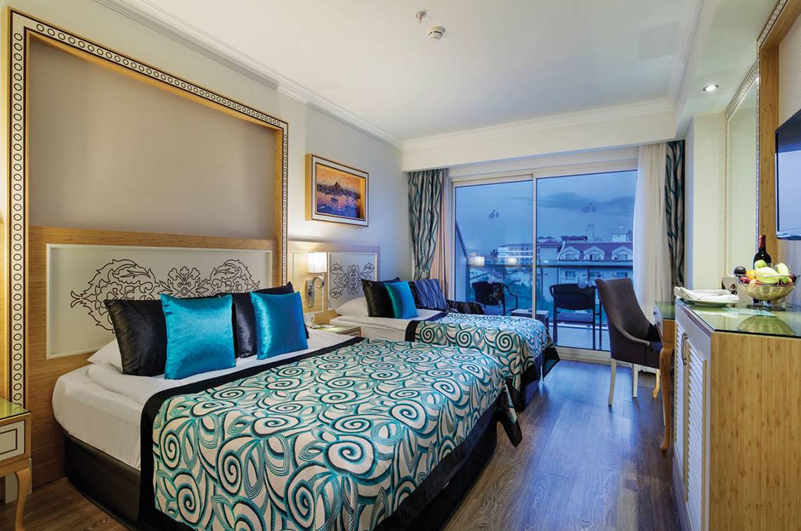 Doppelzimmer mit Balkon im Crystal Waterworld Aqua Collection Hotel, mit zwei Betten und Aussicht auf die Stadt.