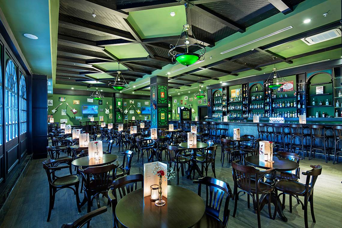 Innenbereich des Crystal Waterworld Aqua Collection Hotels mit Bar und Tischen.