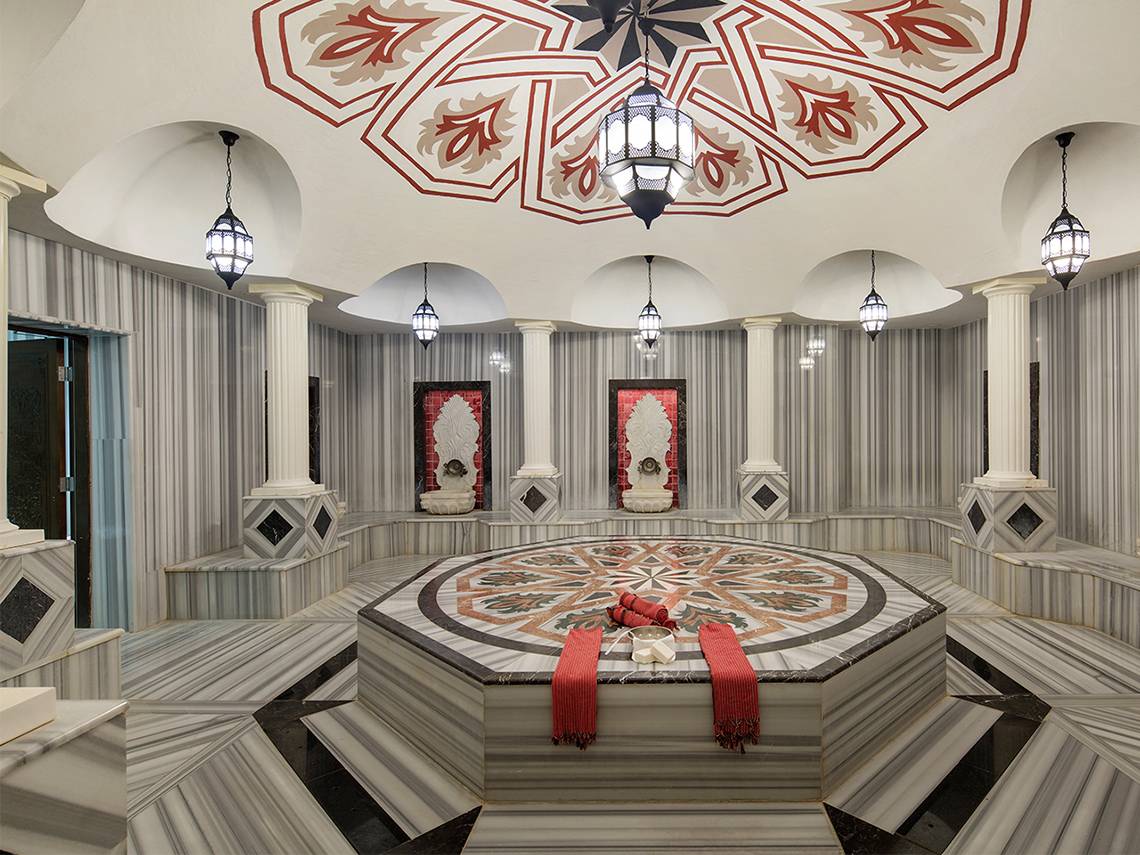 Innenraum des Crystal Waterworld Aqua Collection Spa mit Marmorboden, dekorativen Lampen und zentralem Saunabereich.