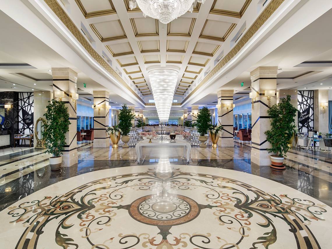 Hotellobby mit großen Kristallleuchten und einem kunstvollen Marmorbodendesign.
