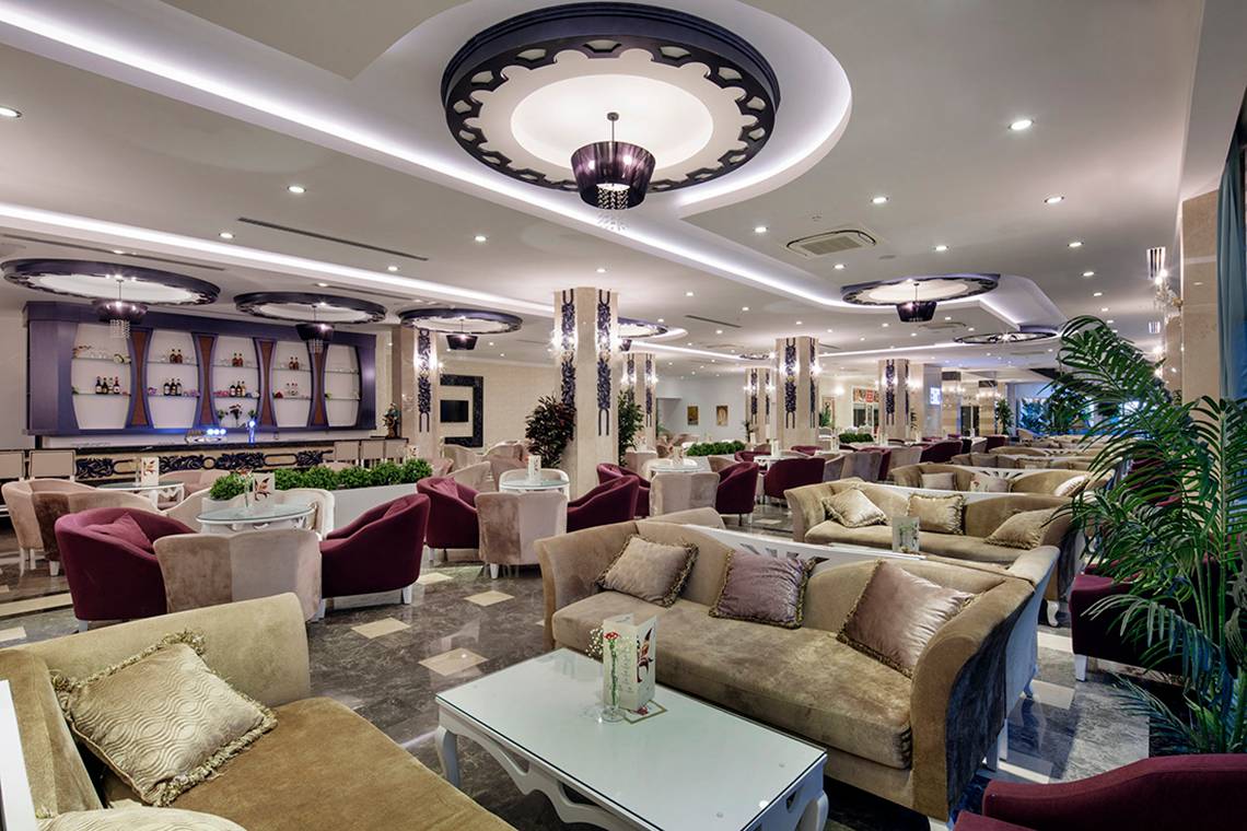 Innenansicht des Crystal Waterworld Resorts mit vielen Sofas, Tischen und Leuchten.