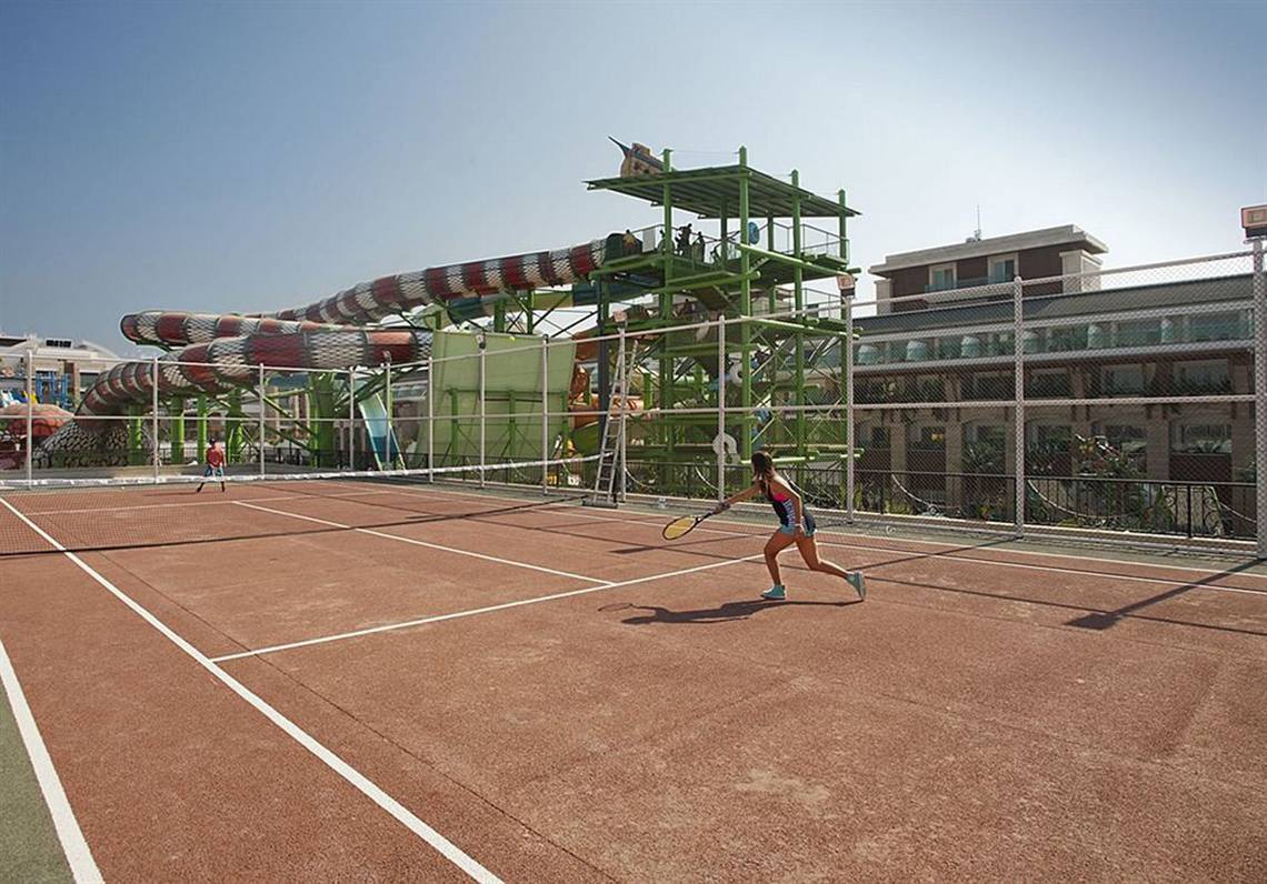 Tennisplatz im Crystal Waterworld Aqua Collection Hotel mit Wasserrutsche im Hintergrund