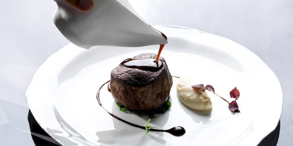 Ein Steakgericht auf einem weißen Teller im Myconian Villa Collection Hotel.
