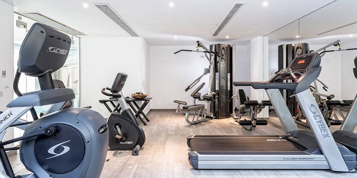 Fitnesscenter im Myconian Villa Collection Hotel mit modernen Geräten und hellem Ambiente.