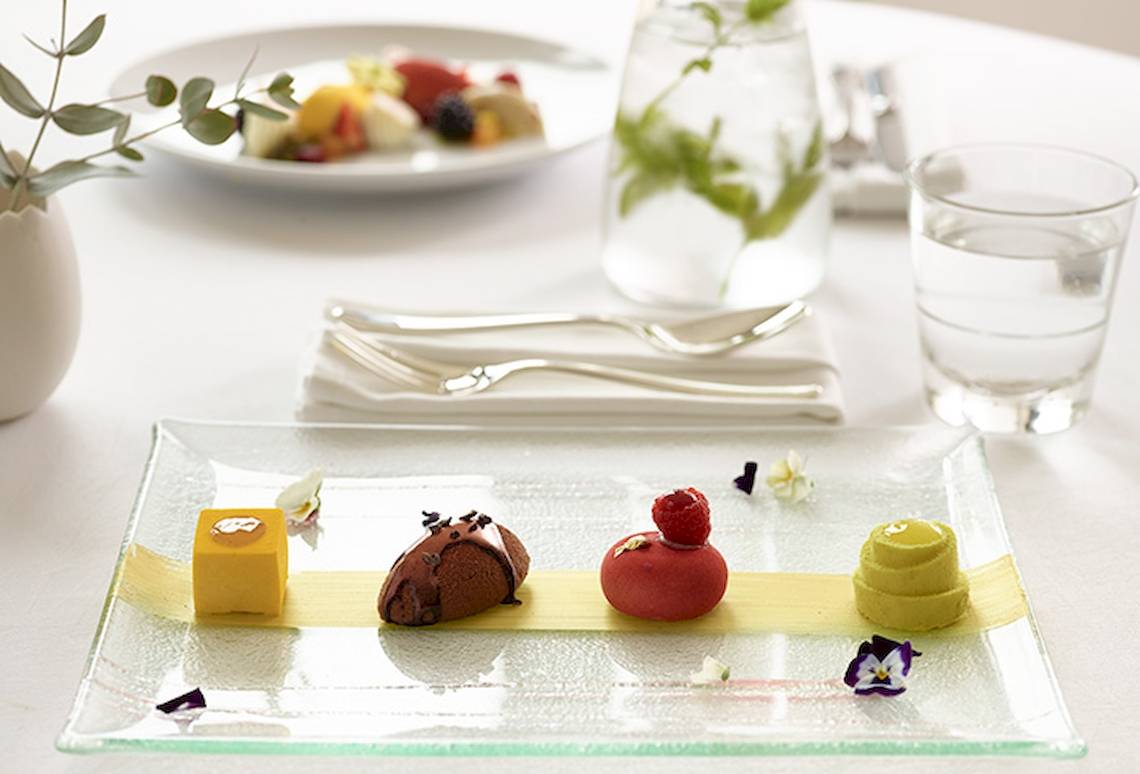 Ein Frühstücksbuffet im Grecotel Mykonos Blu mit verschiedenen Desserts und Früchten.