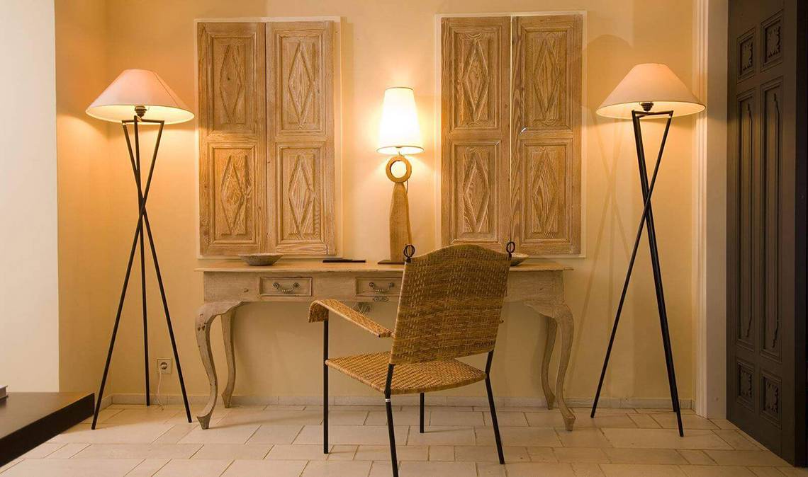Arbeitsplatz im Zimmer im Marmara Bodrum Hotel mit Schreibtisch, Stuhl, Lampen und dekorativen Türen.