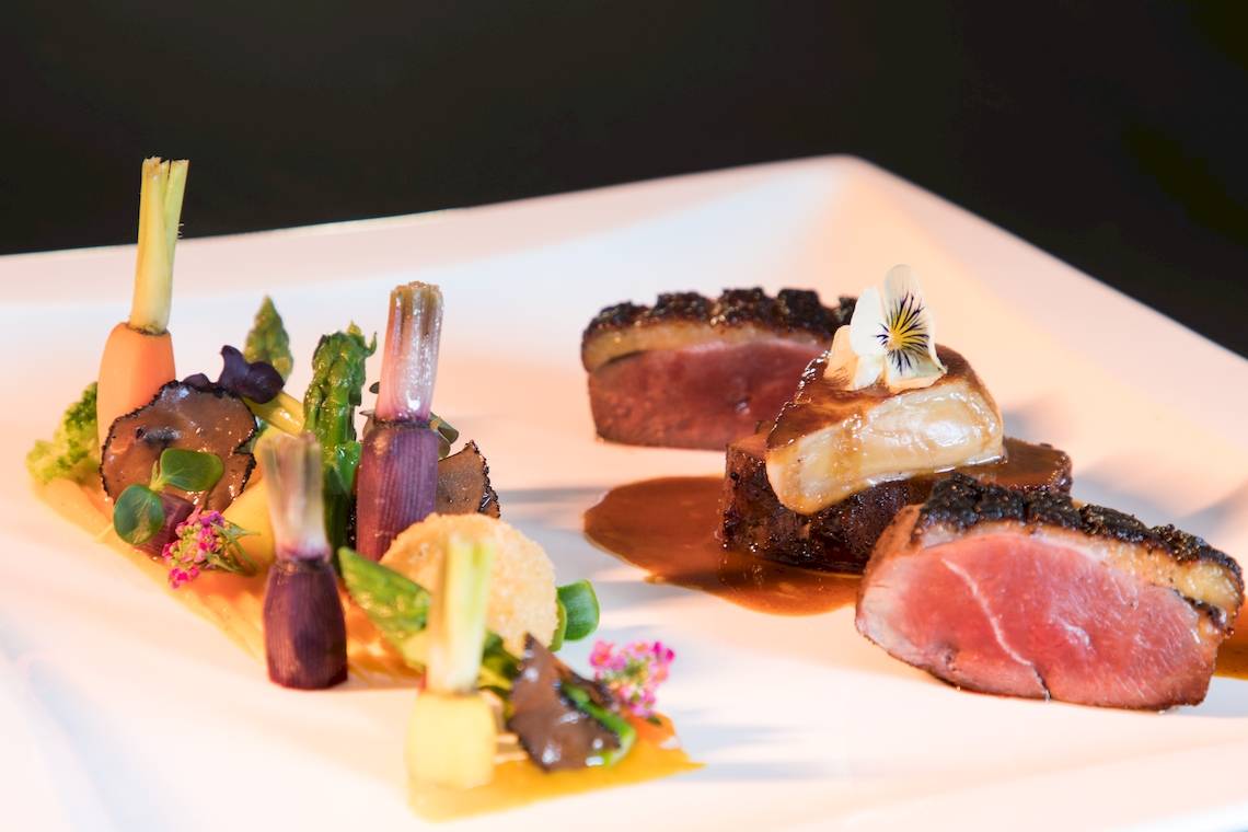 Elegantes Gericht von Seasense Boutique Hotel & Spa mit Fleisch, Gemüse und Sauce.