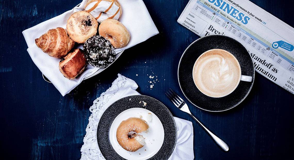 Frühstücksplatte mit verschiedenen Donuts, Croissants und einem Kaffee im Dukes The Palm, a Royal Hideaway Hotel.