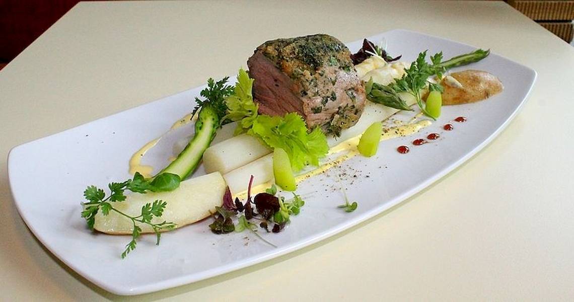 Zeitgeist Vienna Hauptbahnhof Gericht mit Fleisch, Gemüse und Beilagen auf weißem Teller