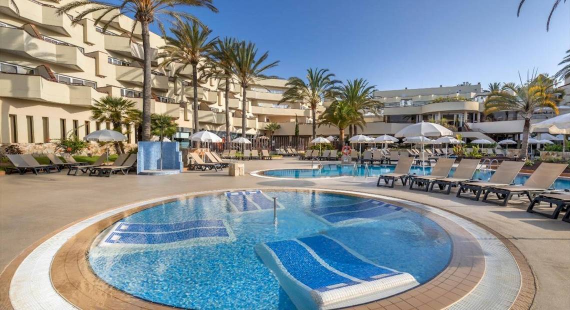Außenbereich des Hotels Barcelo Corralejo Bay mit Swimmingpool und Liegestühlen
