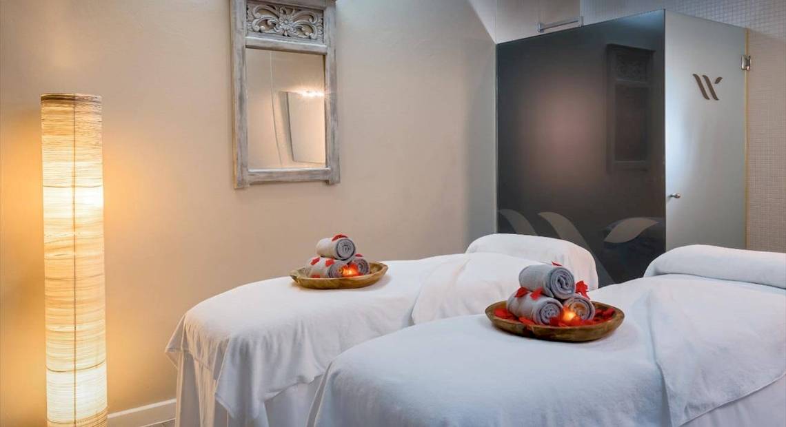 Behandlungsraum im Barcelo Corralejo Bay Hotel mit zwei Massageliegen und einem Spiegel.