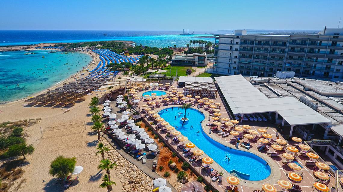 Gesamtansicht des Asterias Beach Hotels mit Strand, Pool und Gebäuden