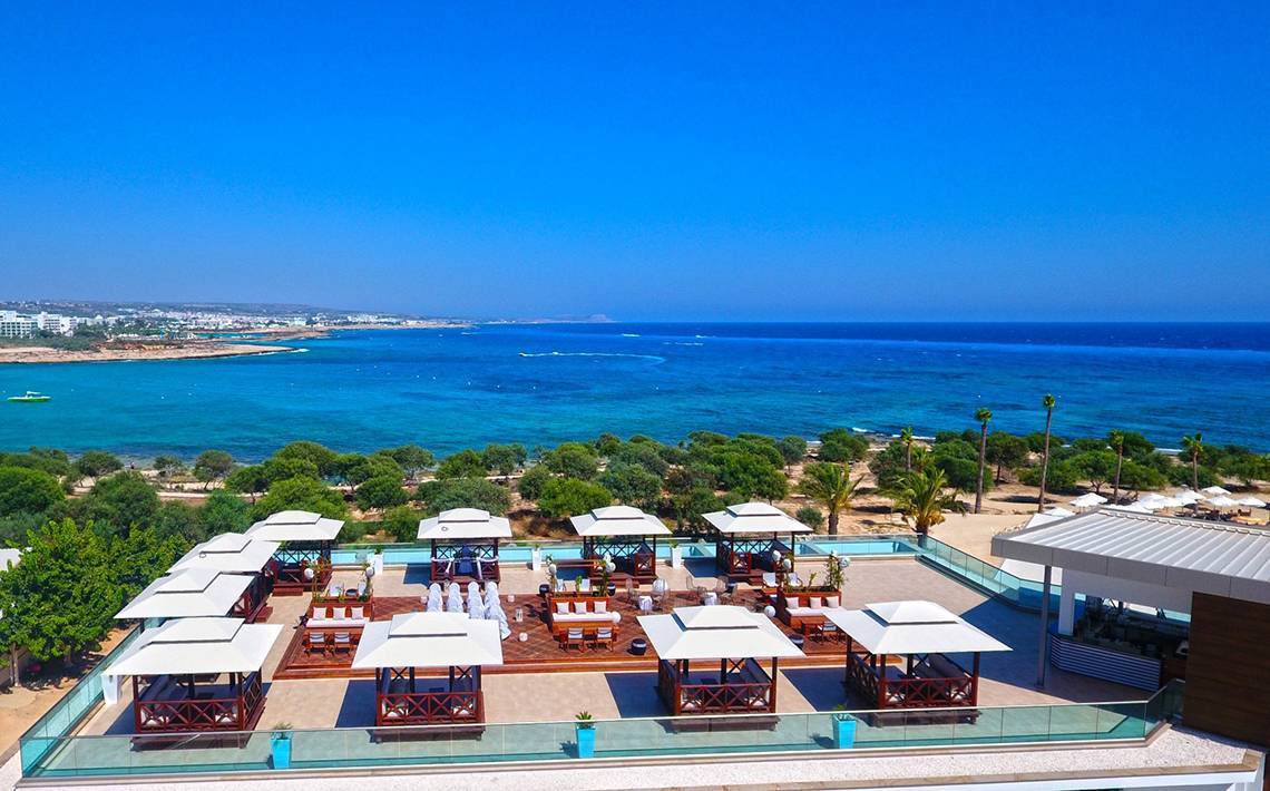 Oberirdische Terrasse des Asterias Beach Hotels mit Blick auf das Meer.