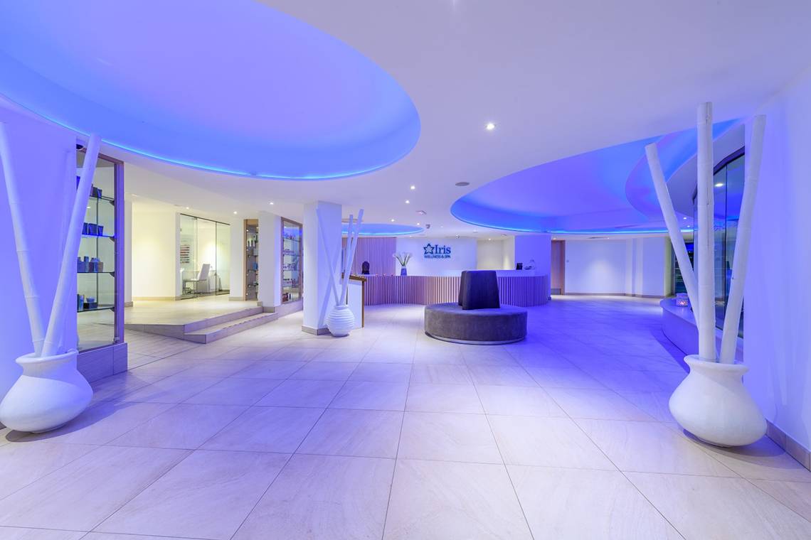 Empfangsbereich des Asterias Beach Hotels mit violetten Beleuchtung und modernem Design.