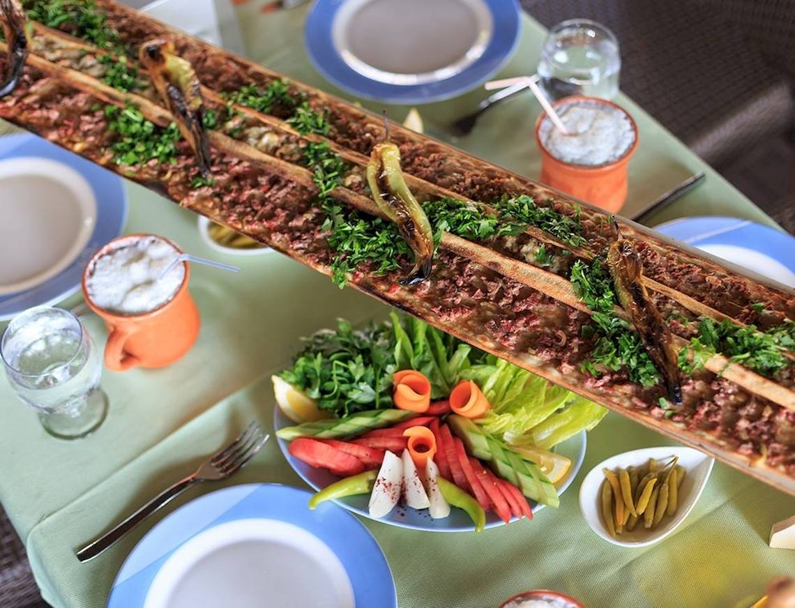 Ein Tisch mit Essen, Getränken und Salat, serviert im Sunis Elita Beach Resort Hotel & Spa.