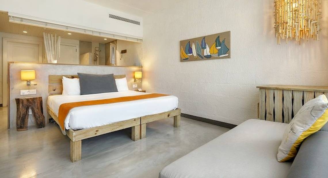 Ein modernes Hotelzimmer mit einem großen Bett, Holzmöbeln und Kunst an der Wand.