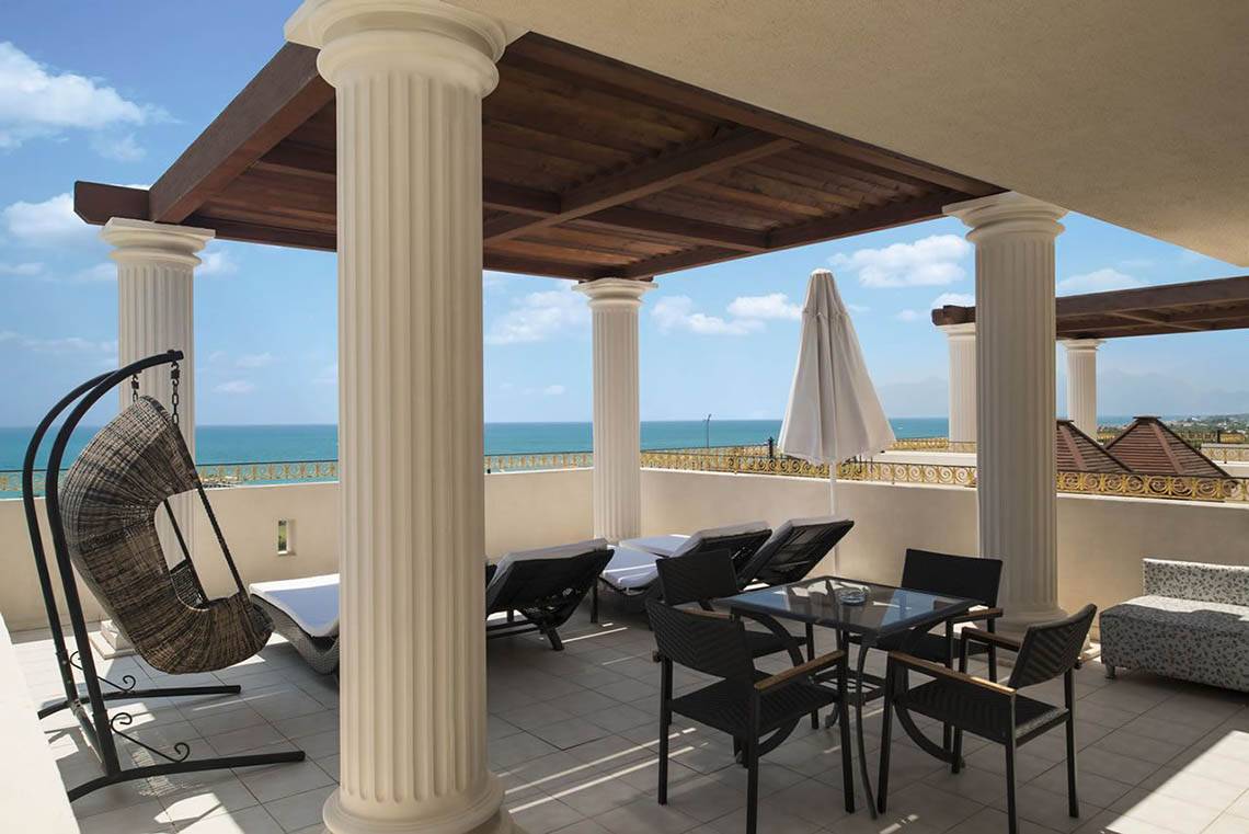 Terrasse des Delphin Diva Premiere Hotels mit Blick auf das Meer und weißen Säulen.