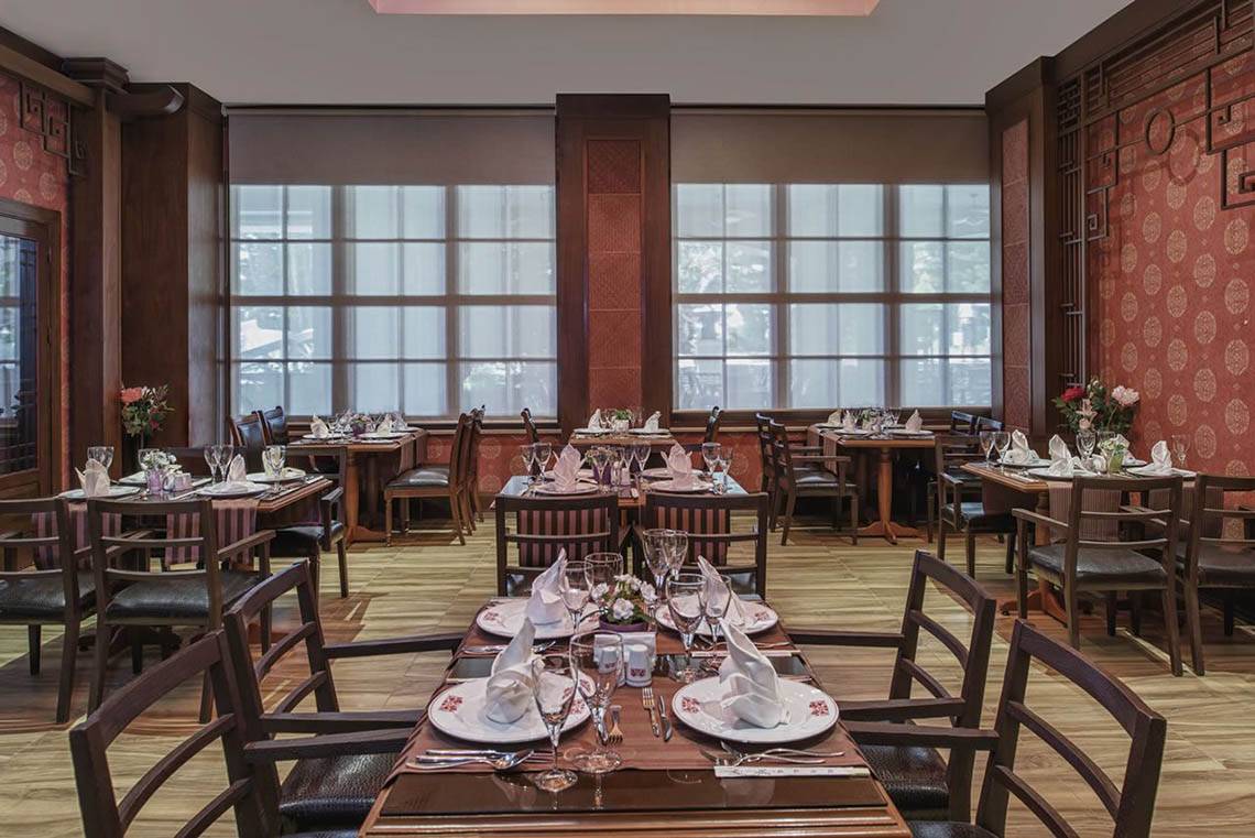 Innenansicht des Restaurants im Delphin Diva Premiere Hotel mit gedeckten Tischen und Stühlen.