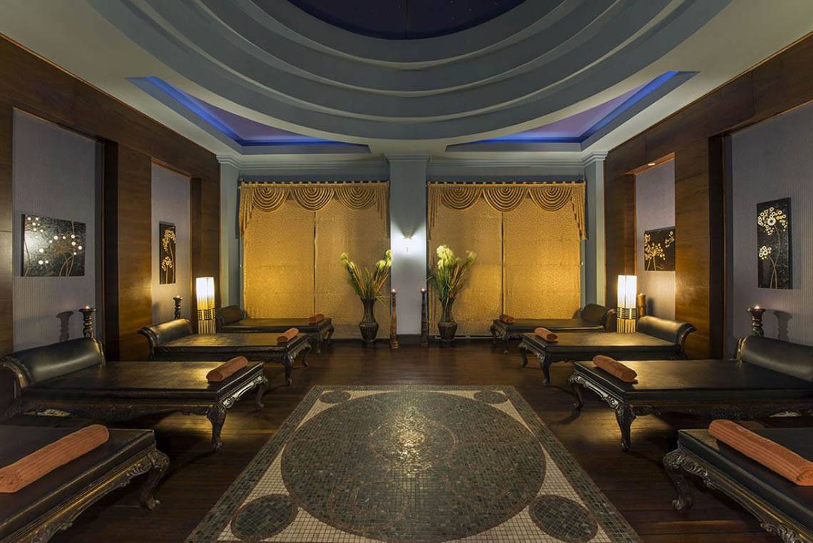 Spa-Lounge im Delphin Diva Premiere Hotel mit schwarzen Liegen und goldenen Vorhängen.