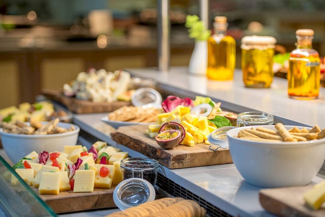 Buffettisch im Star Beach Village & Water Park mit Käseplatten, Crackern und Ölflaschen.