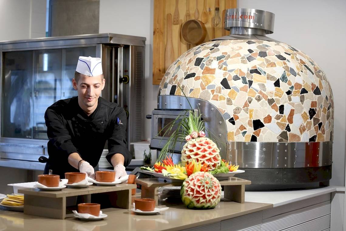 Koch im Star Beach Village & Water Park Hotel serviert Essen auf der Theke