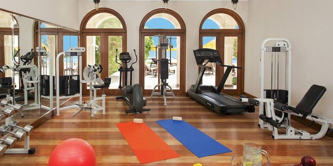 Fitnessstudio im Oberoi Beach Resort mit Geräten, Matten und einer Aussicht auf das Meer.