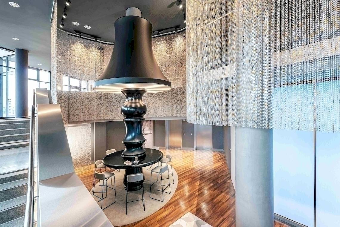 Foyer des NH Berlin Alexanderplatz Hotels mit einer großen schwarzen Tischlampe.